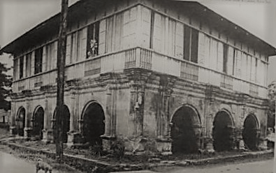 A historic Bahay na Bato, featuring a blend of stone and wooden architecture, with arcades and large windows adorned with Capiz shells, capturing traditional Filipino colonial design.