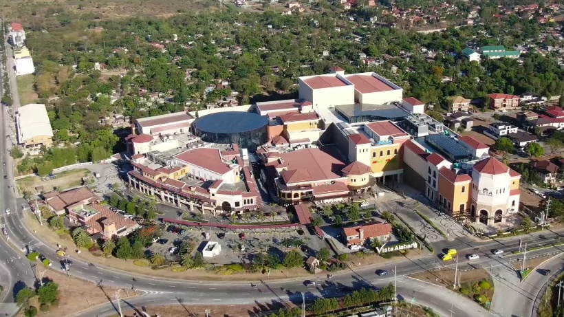 Aerial view of Vista Alabang, showcasing a vibrant shopping complex surrounded by greenery and residential areas.