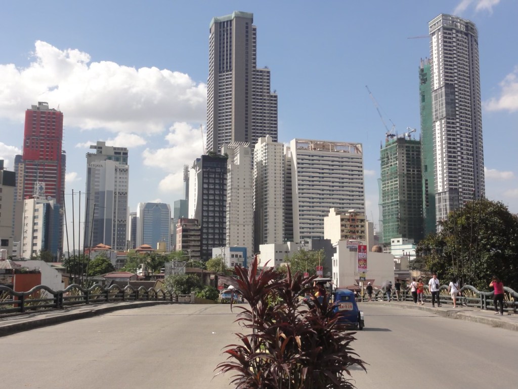 A view of the modern skyline in Metro Manila featuring various high-rise buildings, showcasing a blend of contemporary architecture and urban development.