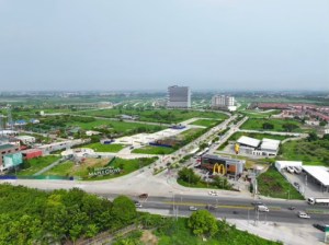 Aerial view of a developing area in Cavite, showcasing green landscapes, new infrastructure, and residential buildings.
