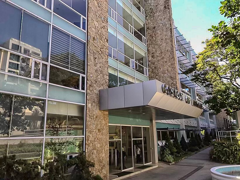 Entrance to a modern residential building with glass and stone features, showcasing a sleek design.