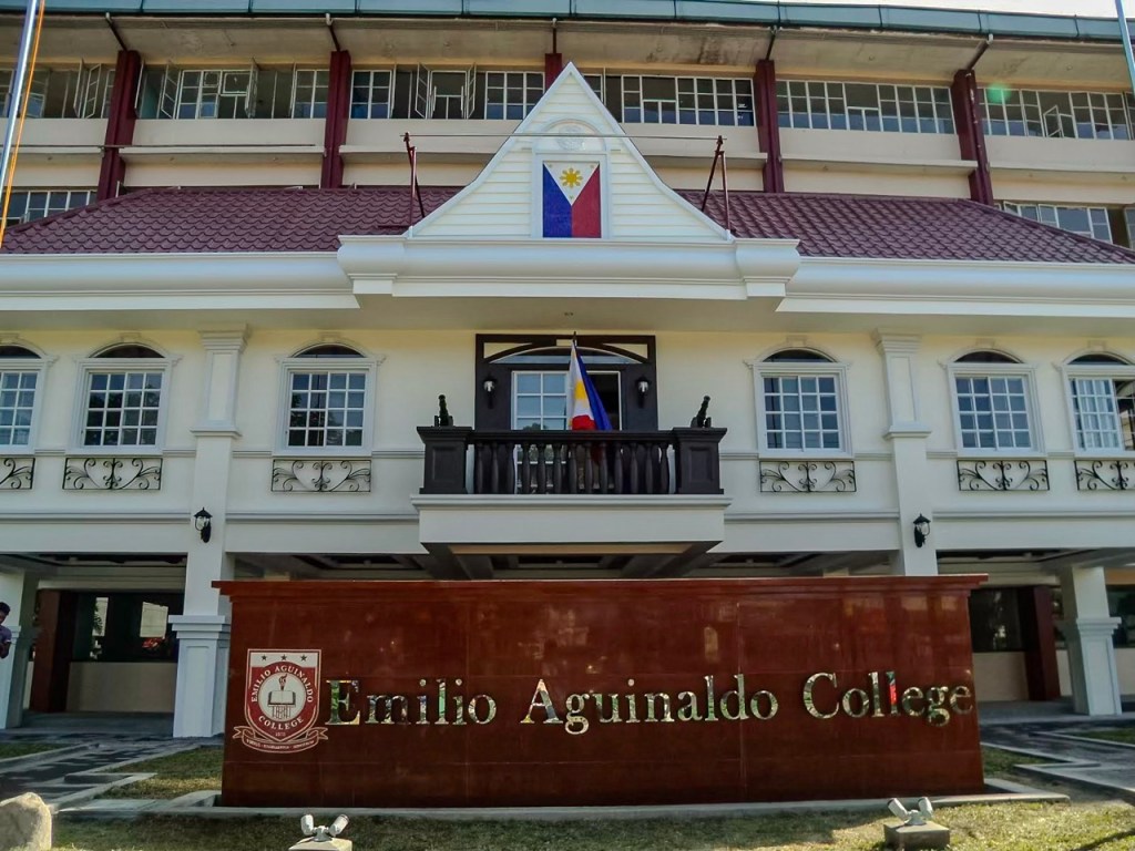 Facade of Emilio Aguinaldo College featuring the Philippine flag and a prominent sign displaying the college's name.