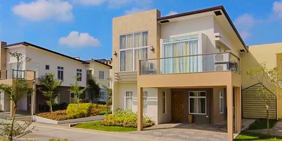 Modern residential house in a suburban community, featuring a balcony and landscaped front yard.